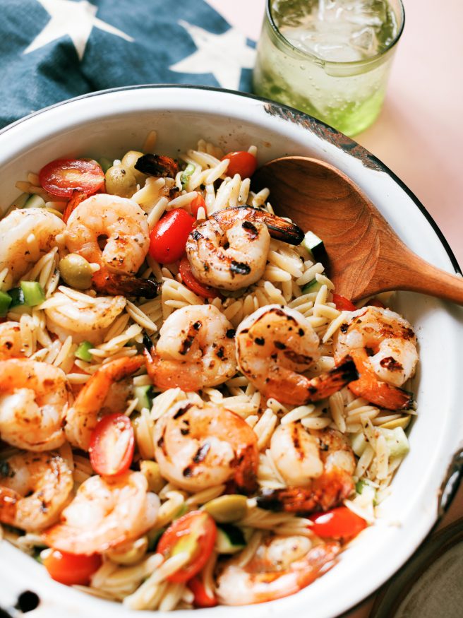 Zesty Grilled Shrimp, orzo pasta coated in an oil and vinegar based dressing with cucumber bell pepper cherry tomatoes. One of my favorite summer meals!