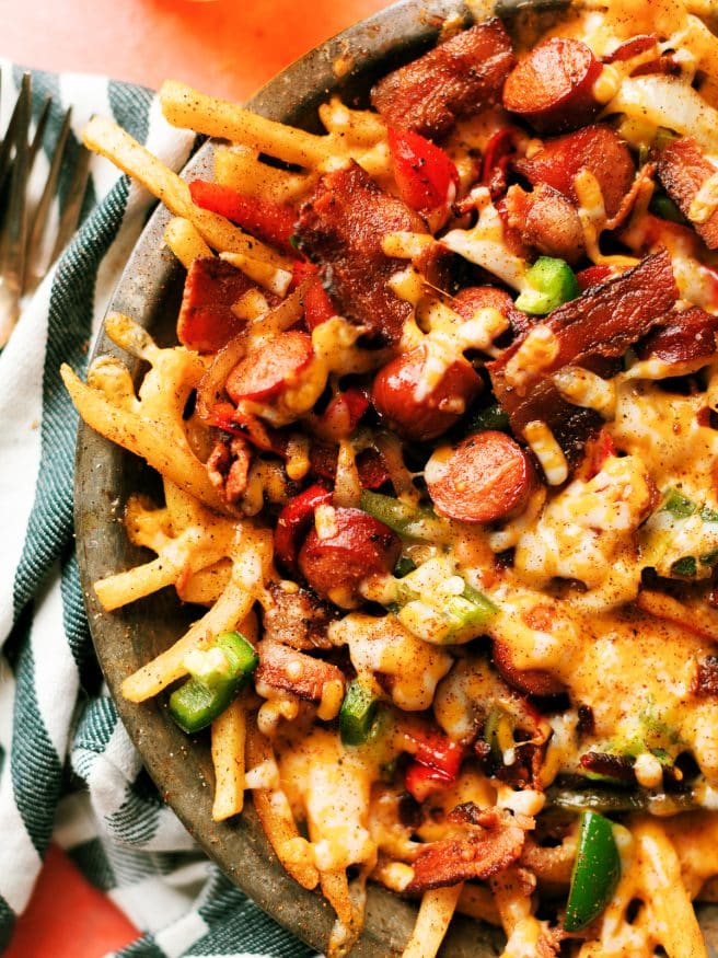 LA Street Meat Cheese fries are topped with cheese, hot dog, peppers and onion, and a spicy fry seasoning that is out of this world. You need to try this!