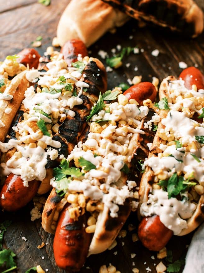 Grilled Andouille sausage hot dog, topped with grilled corn with a little elote seasoning, and a cilantro aioli. It's an explosion of flavors in one bite.